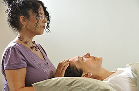 Client receiving Reiki at the top of her head (the crown chakra)